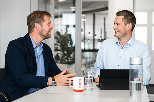 Two men discussing a project at a table.